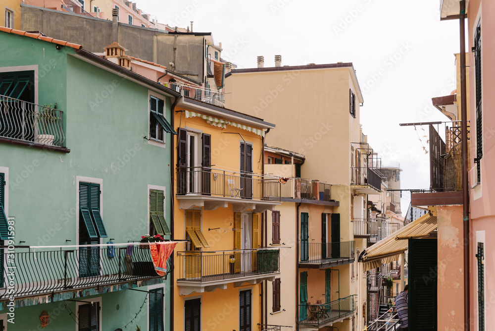 Wooden shutters on a bright Italian houses. Balconies and a narrow Italian street