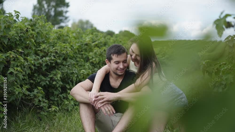 Couple in love embraces and talks on path among plantation Couple in love embraces and talks on path among plantation