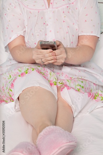 Low section of woman text messaging with legs crossed at ankle