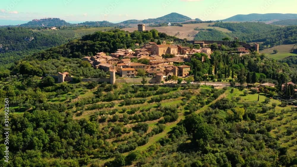 An Italian village with green meadows all over the village. Aerial view with a drone of the beautiful and old village of Monticchiello in Tuscany, Italy An Italian village with green meadows all over the village. Aerial view with a drone of the beautiful and old village of Monticchiello in Tuscany, Italy