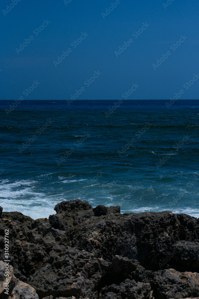 Mar estrellando contra piedras en la playa