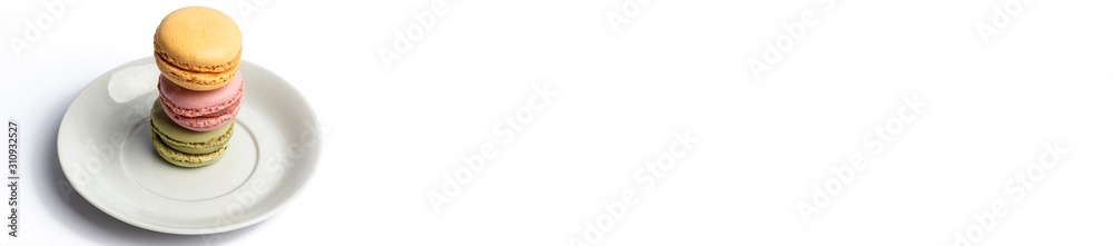 three macaroons stacked on a dish with white background panorama three macaroons stacked on a dish with white background panorama