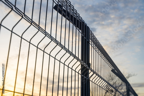 Steel grating fence made with wire on blue sky background. Sectional fencing installation