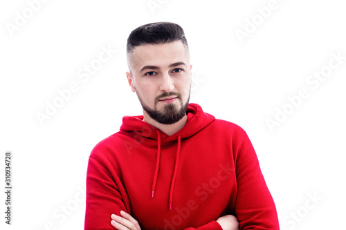 Handsome man in red casual clothes posing with arms crossed on white background
