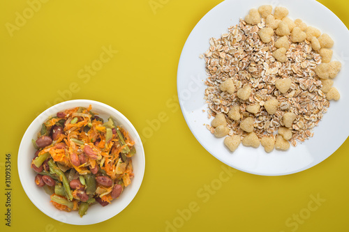 Healthy breakfast on a white plate on a colored background. Muesli with vegetable salad top view photo