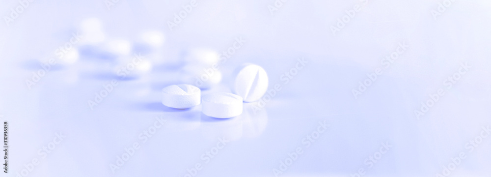 Medicine, pharmacy, pills. White pills on a light blue background. A scattering of tablets. Blurred background. Healthy lifestyle. Background for web site - obrazy, fototapety, plakaty 