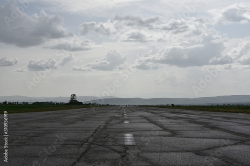 Wet abandoned runway near Sapareva Banya, Bulgaria, nowadays used as rally racetrack. Dark cloudy day.  photo