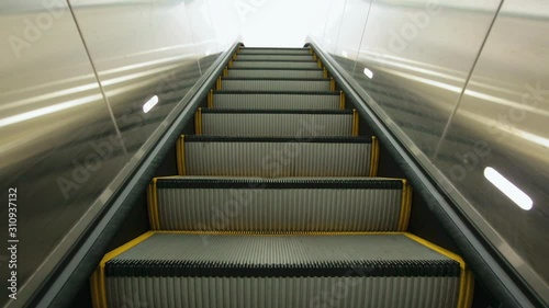 Point of View of escalator stairs moving up from underground to the outside