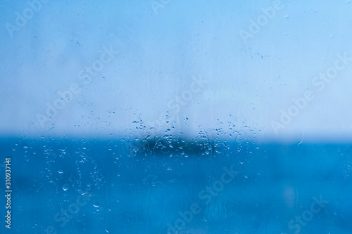 Blue window glass with drops and blurs