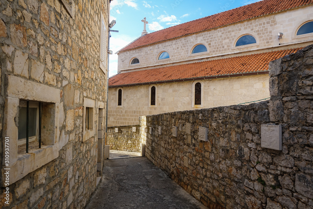 Supetar, Croatia / June 27th 2018: Stone houses and narrow streets in old town Supetar, Brac Island. Croatia, Europe