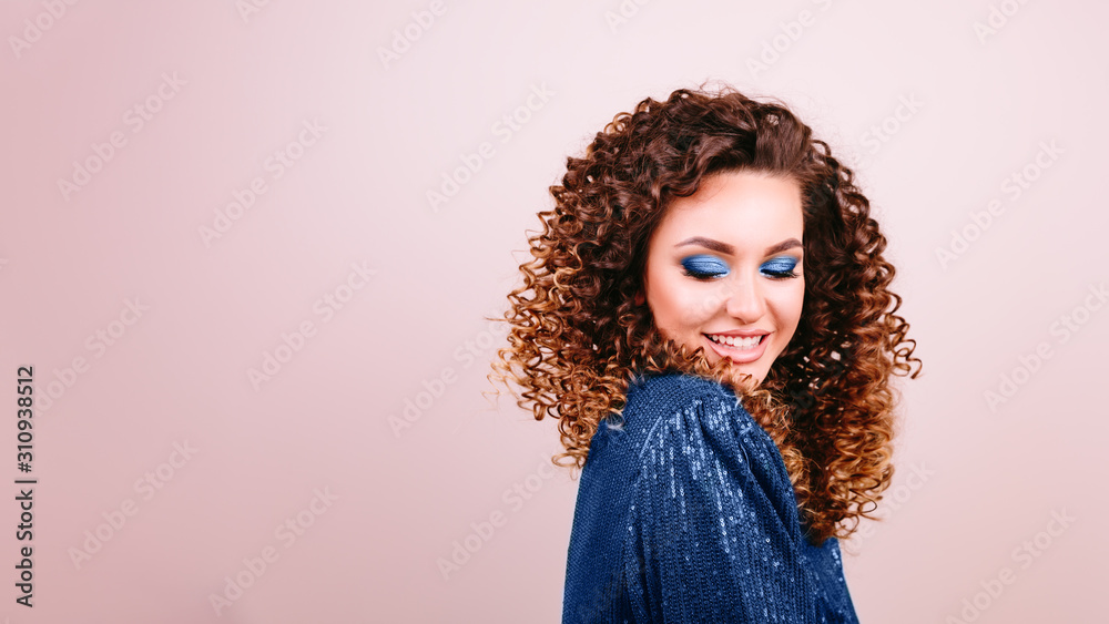 Sexy fashionable woman smiling in glitter blue dress and high heels, nice dark hair. Studio photo. Party concept. Classic blue color of year 2020