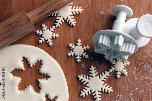 Canvastavla Flat lay snowflakes made from sugar paste on wooden board with rolling pin, plunger or cutter mold, sugarcraft fondant, cake decorating