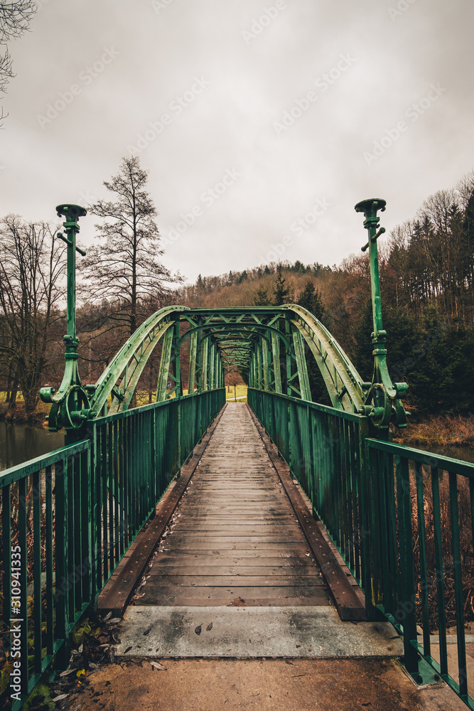 Fototapeta premium Old green metal bridge with wooden path.