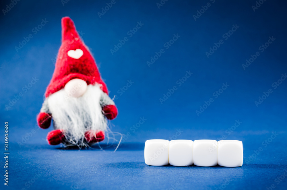 Fototapeta premium Four blank white blocks with christmas dwarf in a conceptual image. Blue background.