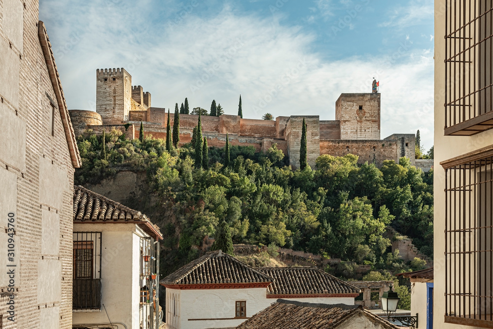 Cityscape of the famous Alhambra’s palace in Granada, Spain. Low angle view of the majestic Muslim palace and fortress
