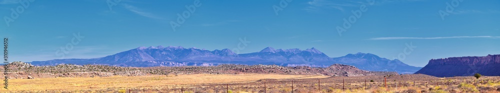 Fototapeta premium Looking back towards Moab Panorama views of desert mountain ranges along Highway 191 in Utah in fall. Scenic nature near Canyonlands and Arches National Park. United States of America. USA.