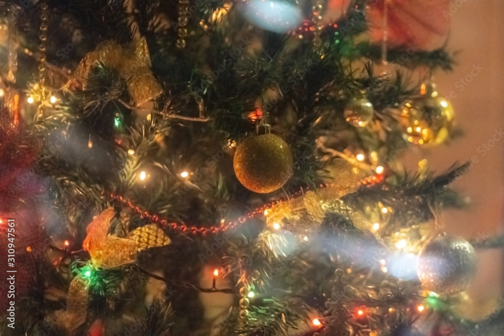 Christmas tree background - baubles and branch of spruce tree. Defocused