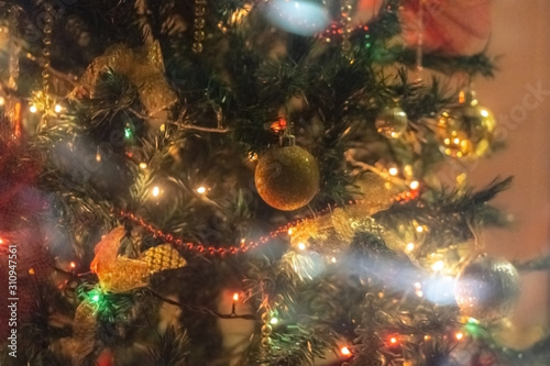 Christmas tree background - baubles and branch of spruce tree. Defocused