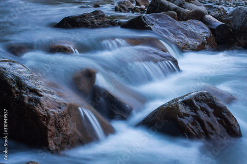 Wild nature concept. Raging mountain river running fast between small rocks and stones.