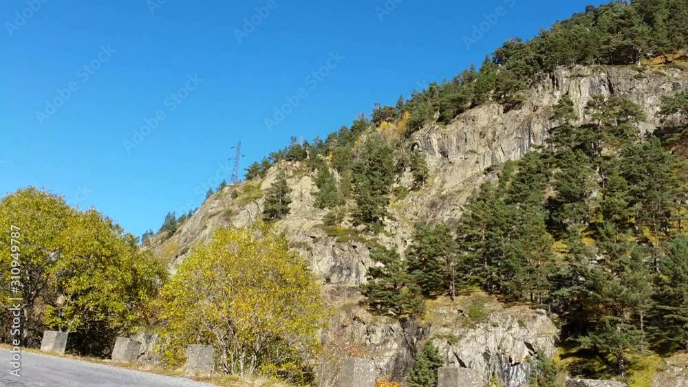 Vehicle point of view shot while driving against the sun on a sinuous road climbing in Pyrenees Mountains during the autumn. Vehicle point of view shot while driving against the sun on a sinuous road climbing in Pyrenees Mountains during the autumn.