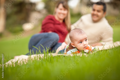 Happy Crawling Baby Boy and Mixed Race Parents Playing in the Park