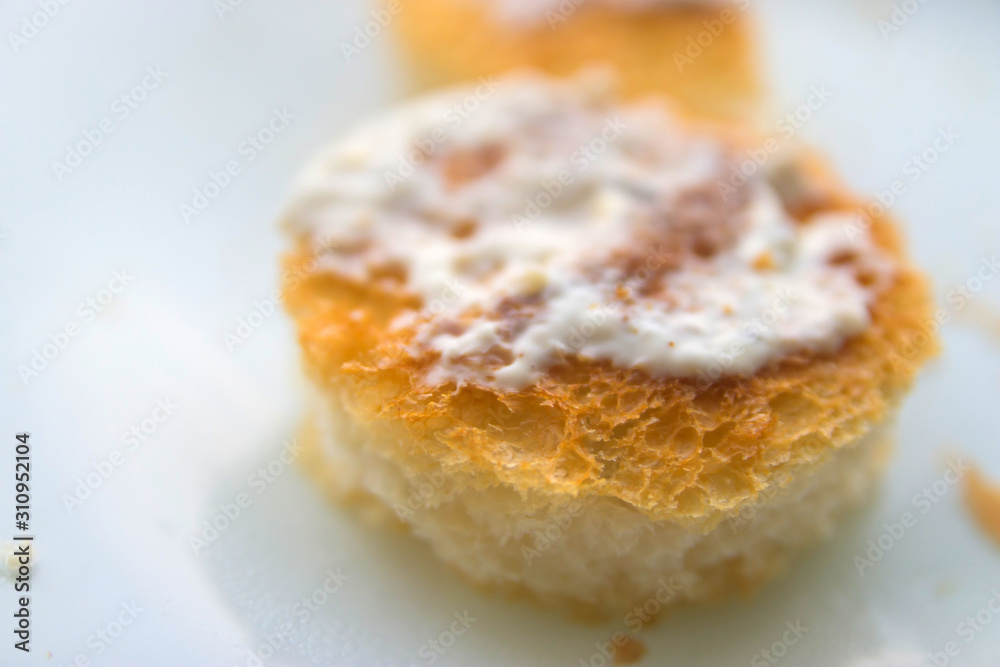 two round croutons with white sauce on top on a white background close up two round croutons with white sauce on top on a white background close up
