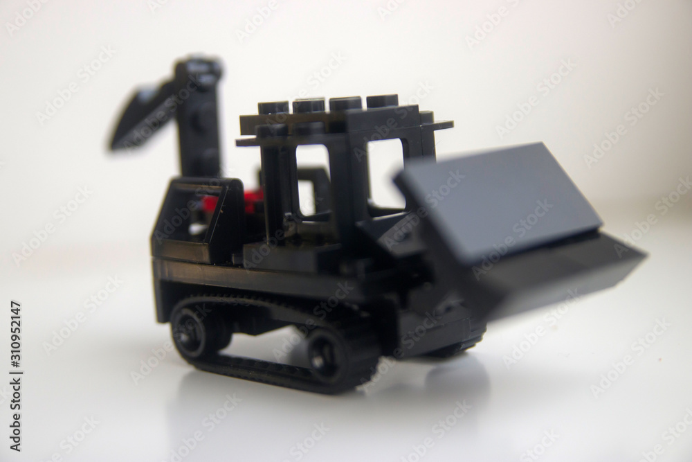 black toy bulldozer from designer cubes on white background close up black toy bulldozer from designer cubes on white background close up