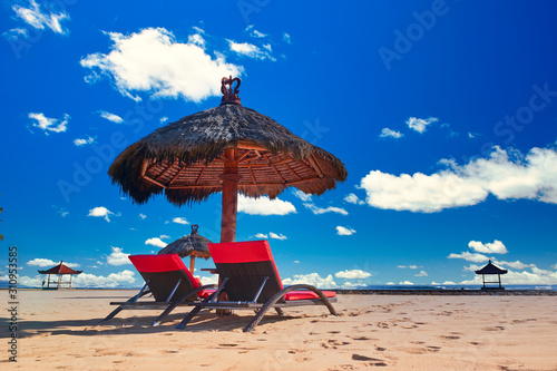 Day time tropic beach with parasol and chear under hot sun and blue light