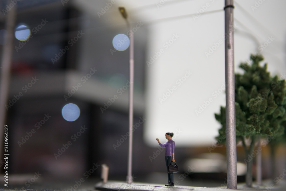 Selective focus of doll figure adult woman standing at pedestrian walkway with blurred background. Selective focus of doll figure adult woman standing at pedestrian walkway with blurred background.