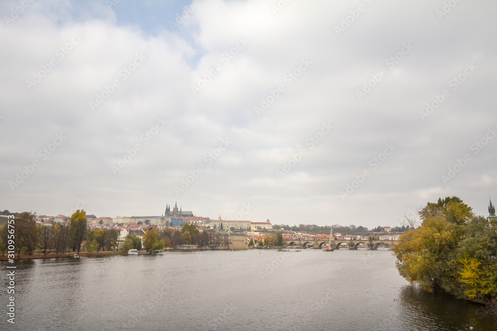 Obraz premium Panorama of the Old Town of Prague, Czech Republic, with a focus on Charles bridge (Karluv Most) and the Prague Castle (Prazsky hrad) seen from the Vltava river. The castle is a touristic landmark 