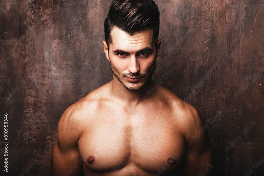 Portrait of handsome young man with stylish haircut posing over rusty wall background. Perfect hair & skin. Close up. Studio shot Portrait of handsome young man with stylish haircut posing over rusty wall background. Perfect hair & skin. Close up. Studio shot