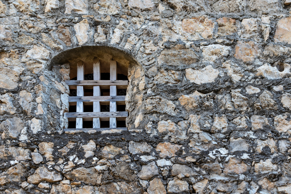 iron bars in medieval castle window and stone old wall of a medieval An Felipe castle construction in Guatemala. Background.