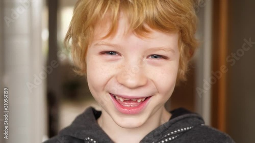 Boy with milk tooth gap laughs wonderfully at the camera