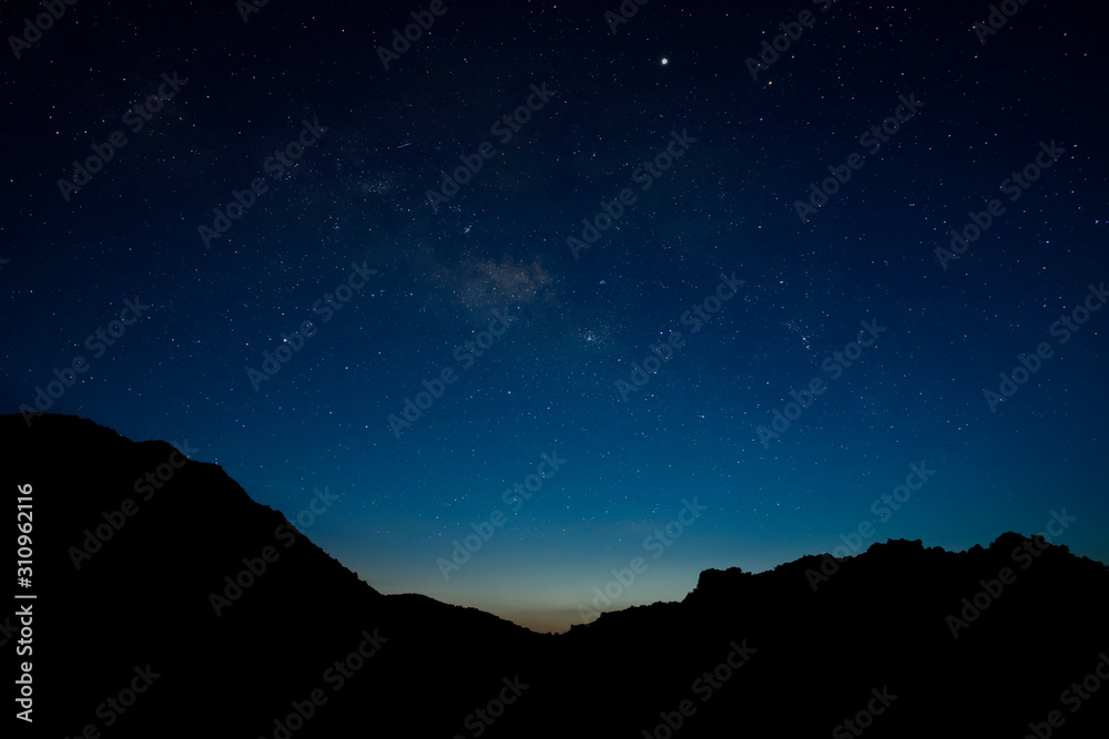 The blue sky with star is above the silhouette mountain in the twilight after sunset