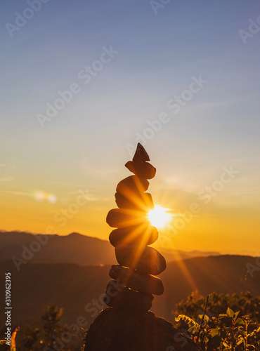 Nature stones stacked on abstract sunset background photo