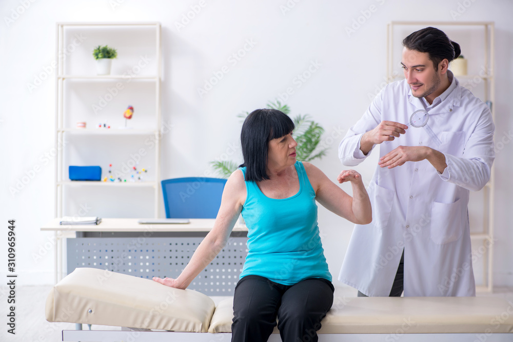 Young male doctor examining old female patient Young male doctor examining old female patient