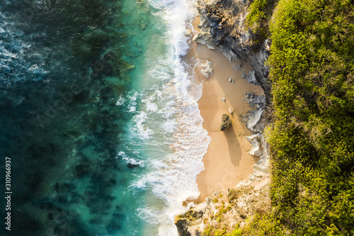 Obraz na płótnie View from above, stunning aerial view of a rocky shore with a beautiful beach bathed by a rough sea during sunset, Nyang Nyang Beach (Pantai Nyang Nyang), South Bali, Indonesia. w salonie