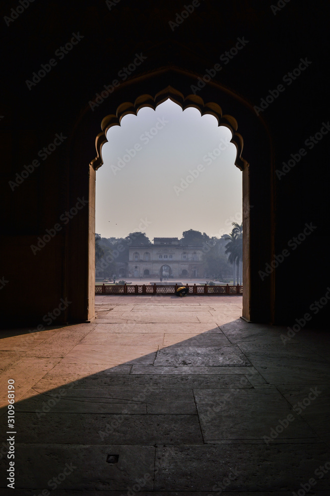 A mesmerizing view with sun rays create dramatic light and shadow of inside the hall of safdarjung tomb memorial from the main gate,entrance at winter morning.