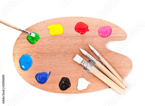 Palette with paints and brushes isolated on a white background.