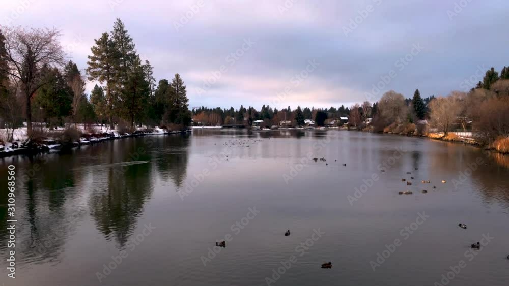 Winter clip of Drake Park in Bend Oregon, birds fly over water.