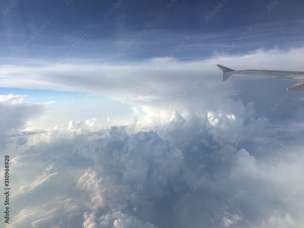 an aerial view of mushroom shaped clouds from airplane cockpit window, horizontal form an aerial view of mushroom shaped clouds from airplane cockpit window, horizontal form