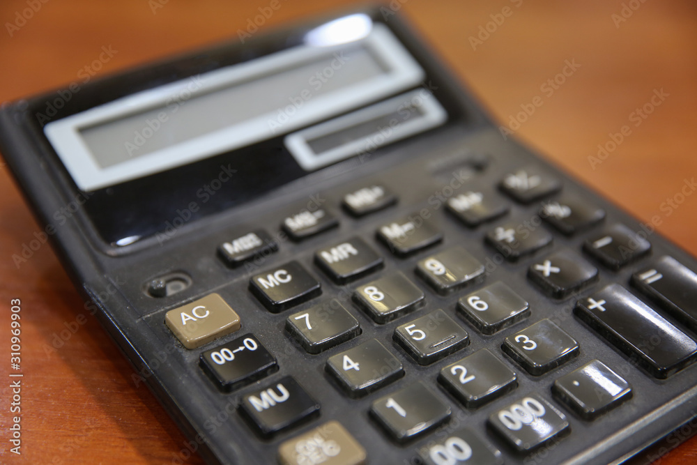 Old calculator on a wooden table. Close-up Old calculator on a wooden table. Close-up