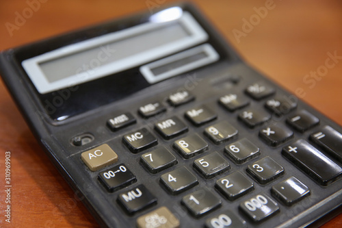 Old calculator on a wooden table. Close-up