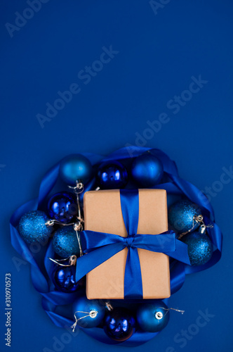 New Year's gift on a blue background, with a beautiful satin ribbon. Christmas. New Year's content.