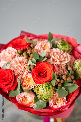 European floral shop. Beautiful bouquet of mixed flowers in glas vase. the work of the florist at a flower shop. Delivery fresh cut flower.