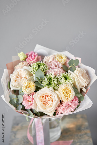 European floral shop. Beautiful bouquet of mixed flowers in glas vase. the work of the florist at a flower shop. Delivery fresh cut flower.