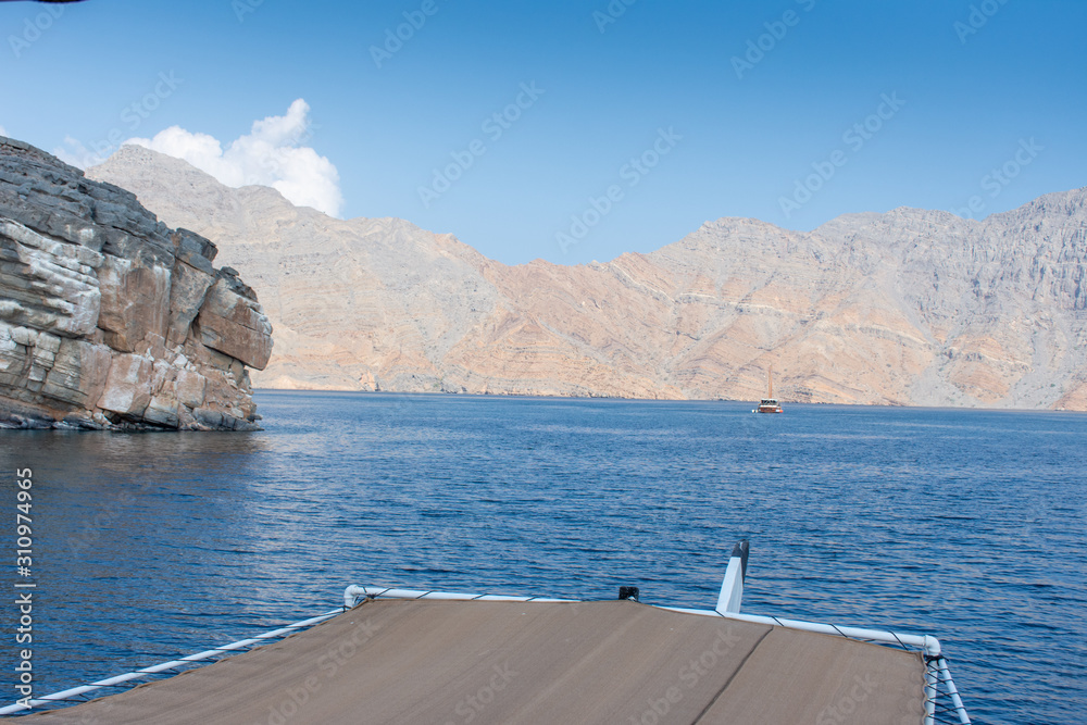 Obraz premium View from Dhow Boat to spectacular rocky mountains of northern Oman in Musandam in the fjords.