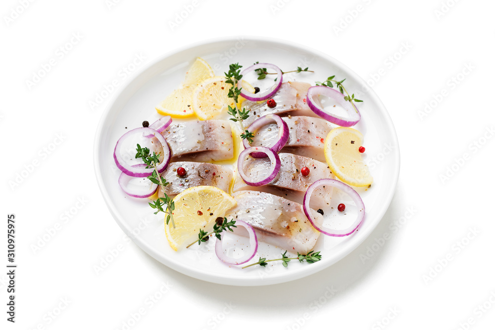 Salted herring with spices, lemon and red onion rings isolated on white background. Marinated sliced fish. Salted herring with spices, lemon and red onion rings isolated on white background. Marinated sliced fish.