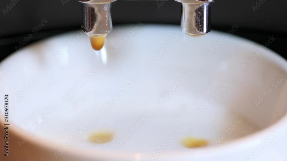 Adding shot of fresh coffee from espresso machine into white coffee cup with steamed milk, 4k