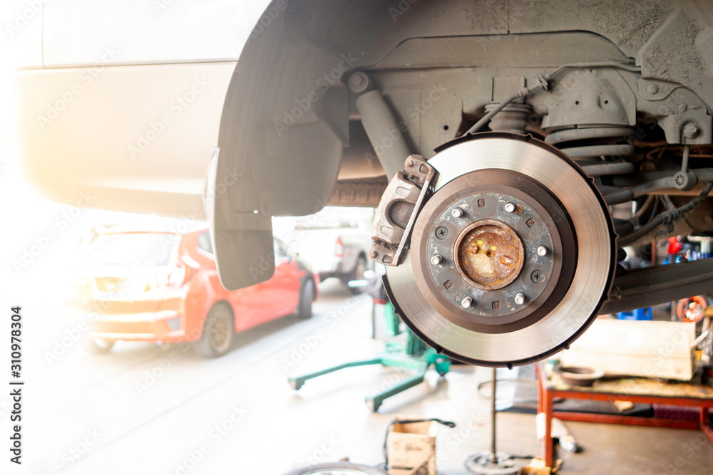 Car service - mechanic unscrewing brake disc of the vehicle for repair. Car service - mechanic unscrewing brake disc of the vehicle for repair.